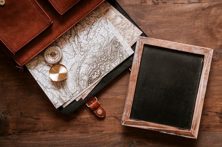 Maps and a small slate on a wooden desk